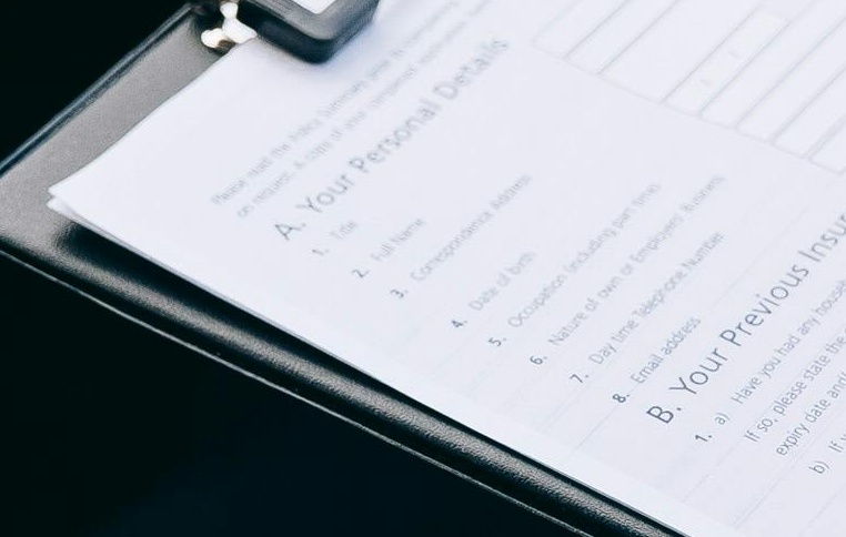 Osoba trzymająca notatnik, obok druga, siedzą w aucie